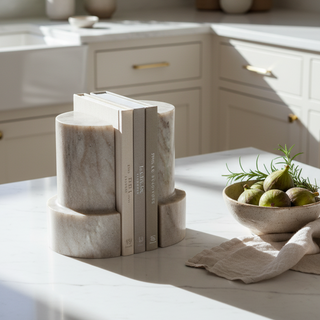 Decorative bookends on a kitchen counter with sunlight casting shadows