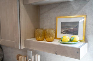 Pepper + Vetiver Petra embossed amber drinking glasses on a kitchen shelf, HGTV Totally 90s House